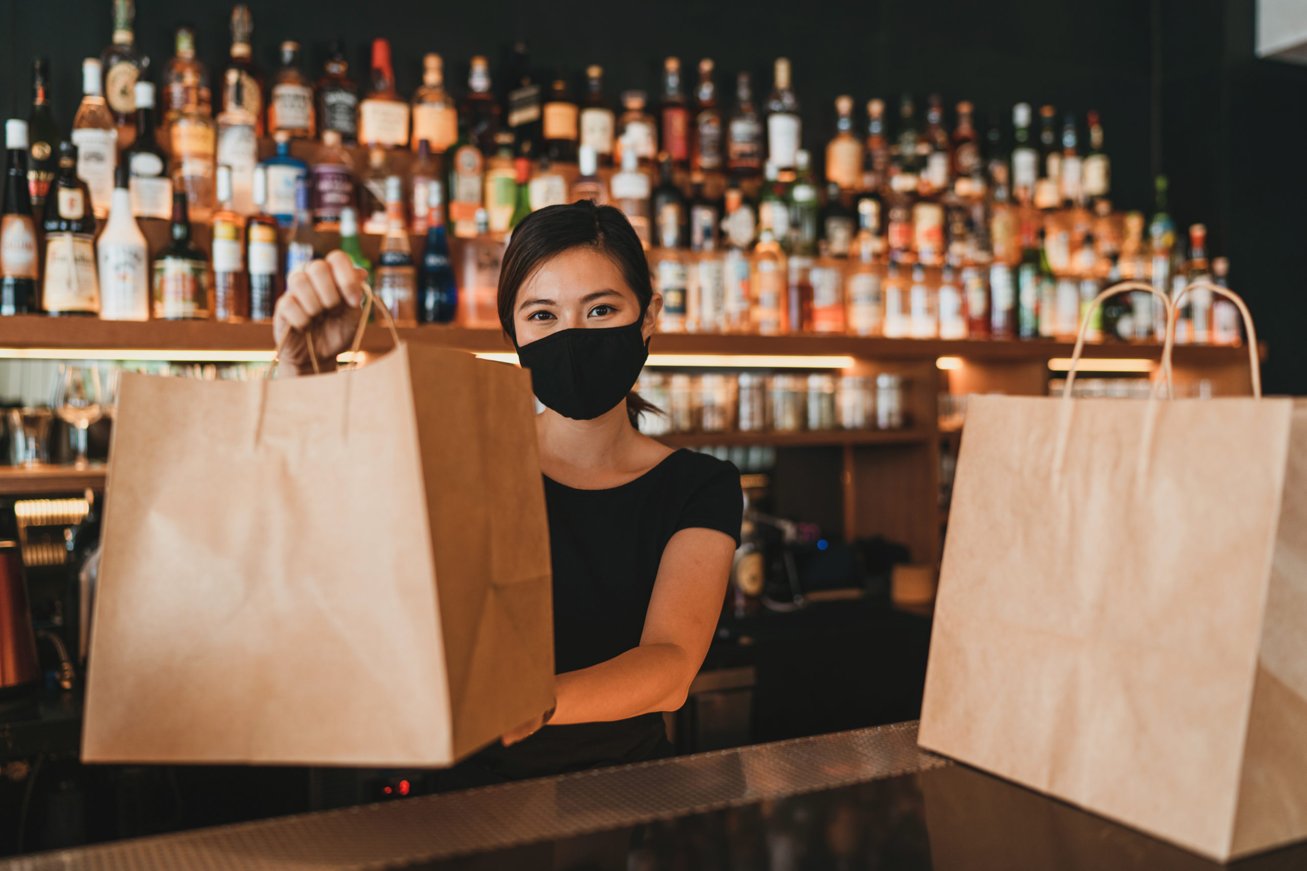 A COVID-19 waitress preparing take out food orders for delivery